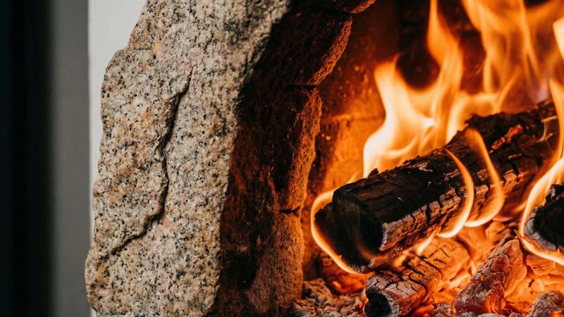 Макросъемка яркого огня и фактуры дикого гранита в топке